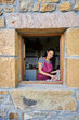 © Alvaro Lavin/Stocksy - Woman smiling preparing fresh vegetables in kitchen window