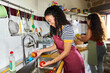 © Alvaro Lavin/Stocksy - Women washing fruits in kitchen preparing healthy meal