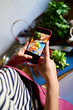 © Alvaro Lavin/Stocksy - Woman photographing chopped vegetables on cutting board with phone