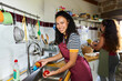 © Alvaro Lavin/Stocksy - Young woman washing fresh apples in kitchen sink