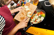 © Alvaro Lavin/Stocksy - Woman cooking fresh vegetables in a pan on stove