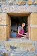 © Alvaro Lavin/Stocksy - Smiling woman unpacking fresh produce in rustic kitchen window