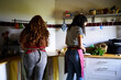 © Alvaro Lavin/Stocksy - Women cooking together preparing food in kitchen