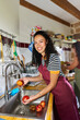 © Alvaro Lavin/Stocksy - Young woman washing fresh fruit in kitchen sink