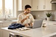 © Ulfa - Man Working on Laptop While Drinking Coffee in Modern Kitchen.