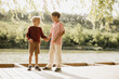 © BGStock72 - Two young boys share a moment by the lake under the warm sunlight