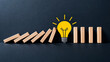 © Syamsul - Creative idea stops domino effect, business risk prevention and innovative problem solving concept on dark background