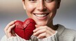 © udiana - Smiling woman holding a cracked red heart symbolizing love