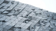 © Tajbeul - Modern futuristic architectural facade with grey geometric triangular metallic panels.