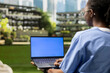 © DC Studio - Medical student holds a laptop with blue mockup screen on campus
