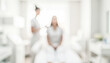 © Zayntech - A blurred image depicting a woman sitting in a spa or beauty treatment room while a facial treatment is being administered by a professional. Bright and serene setting.