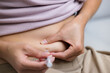 © leungchopan - Woman pinching belly fat preparing ivf injection pen taiwan