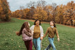 © Halfpoint - Grandmother spending time with granddaugters, walking in autumn nature.