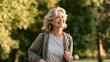 © Uzma Shafique - Mature woman jogging in park listening to music with earphones during