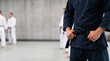 © Kaluya Stock - Martial artist wearing black belt and dark blue gi standing in dojo during training