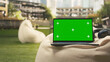 © DC Studio - Chroma key screen on a laptop sits in an outdoor campus setting beside a beanbag and headphones, offering screen replacement in an academic environment.