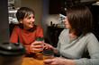 © ADDICTIVE STOCK - Mature women share coffee and conversation at cafe