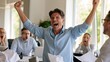 © AZ Studio - Office colleague celebrates a major win as surprised coworkers react around the meeting table