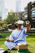 © DC Studio - Black medical student wearing blue scrubs uses VR goggles and controllers in an outdoor campus study session, exploring immersive technology for medical training and simulated learning.
