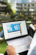 © DC Studio - African American student listens to an online concert video on a laptop during an outdoor campus study break, enjoying live concert music performance content through a streaming platform.