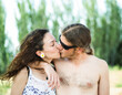 © Antonio Recena - Young 30s hippie couple kissing outdoors in sunset summer day.
