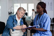 © DC Studio - Paperwork, patient and nurse with older woman signing a medical form on clipboard in hospital waiting area for documentation, appointment processing, healthcare records and routine care.