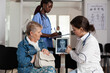 © DC Studio - Doctor, imaging and communication with senior woman patient reviewing diagnostic scan on tablet while nurse documents the hospital consultation, for medical explanation, teamwork and care support.