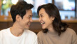 © ezra - Asian Couple's Joyful Moment: A young Asian couple shares a heartfelt laugh, their eyes twinkling with happiness as they gaze at each other, capturing a moment of pure connection and affection.