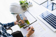 © Charlie's - Male Engineer Planning Solar Energy Business Project with Technology at Office Desk for Renewable Power Investment and Sustainable Development.