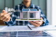 © Charlie's - Male Engineer Planning Solar Energy Business Project with Technology at Office Desk for Renewable Power Investment and Sustainable Development.