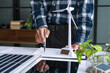 © Charlie's - Male Engineer Planning Solar Energy Business Project with Technology at Office Desk for Renewable Power Investment and Sustainable Development.