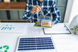 © Charlie's - Male Engineer Planning Solar Energy Business Project with Technology at Office Desk for Renewable Power Investment and Sustainable Development.