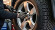 © Gibster - Mechanic performs emergency maintenance service on vehicle tire system with gloves for safety and precision in workshop setting