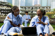 © DC Studio - Medical students, laptop and notebook anchor a collaborative study as one classmate writes and another talks. Peer learning, healthcare training and communication connect learners on a campus lawn.