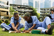 © DC Studio - Medical students, textbooks and group study bring classmates together as they point and write in open books. Peer learning, collaboration and healthcare training unfold on a green campus lawn.