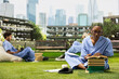 © DC Studio - Medical student, textbooks and study notes fill a focused solo learning session in scrubs on grass. Healthcare education, exam preparation and independent learning shape outdoor campus study.