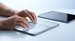 © Moh - Close-up of a person's hands typing on a foldable touchscreen device, with another tablet visible in the background on a white surface