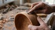 © Victor - Close up of artisan hands sanding a handcrafted wooden bowl in a workshop