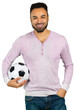 © fotofabrika - Man holds a soccer ball while smiling wearing a light colored sweater with buttons