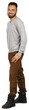 © fotofabrika - Man standing with a smile, wearing gray sweater and brown pants, showing a casual style