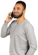 © fotofabrika - Man talking on the phone, smiling while standing indoors near a white background