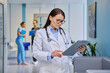 © Valerii Honcharuk - Mature female doctor reading medical clipboard in clinic hallway portrait