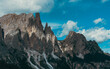 © Vic - Imponenti pareti rocciose e cime frastagliate sovrastano pendii boscosi, sotto suggestive nubi estive, nei pressi delle Cinque Torri, a Cortina d’Ampezzo, nelle Dolomiti venete.