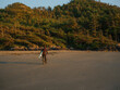 © Anna Tsukanova/Stocksy - Unrecognisable person in a wetsuit on a bike in Tofino, BC