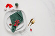 © Pixel-Shot - Christmas dinner table setting, holiday celebration and festive dining with green napkin and gold cutlery on white marble background