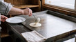 © Debi Kurnia Putra - Pouring Flatbread Batter from Ladle onto Hot Griddle