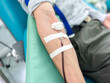 © Krievietka - Blood donation process. Man sits in special chair while medical staff collect blood from his vein. Represents volunteering, saving lives, and supporting blood banks