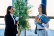 © Valerii Honcharuk - Teacher talking to female student holding folders in modern university hall