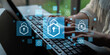 © InfiniteFlow - Close-up View of a Person Typing on a Laptop with Digital Security Icons Overlay Representing Cybersecurity Concepts and Data Protection Strategies Haptic.