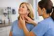 © Rohan Katwe - Nurse practitioner performs thyroid gland examination on middle-aged patient using gentle neck palpation, supporting thyroid screening, endocrine health assessment and preventive primary care.